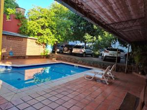 uma piscina com uma cadeira ao lado de uma casa em Terwindt Hotel em Encarnación