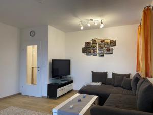 een woonkamer met een bank en een flatscreen-tv bij Wohnung City Nord mit Balkon in Herzogsdorf