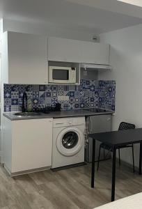 uma cozinha com uma máquina de lavar roupa e um micro-ondas em Carry centre au calme em Carry-le-Rouet