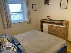 a bedroom with a bed and a dresser and a window at Wohnung City Nord mit Balkon in Herzogsdorf