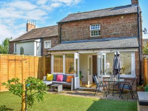 an extension to a brick house with a patio at Ivy Cottage in Warwick