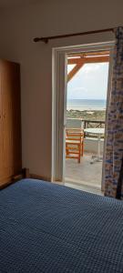 a bedroom with a bed and a view of the ocean at Faros Apartments in Xerokampos