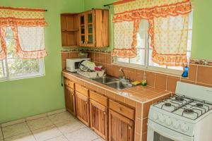 a kitchen with a sink and a stove at Charlie's Cottages in Negril