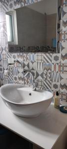 a bathroom with a white sink and a mirror at Faros Apartments in Xerokampos