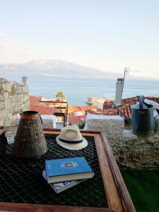 einen Hut und Bücher auf einem Tisch mit Meerblick in der Unterkunft Clock's House in Nafpaktos
