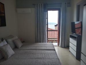 a bedroom with a bed and a window with a view at Clock's House in Nafpaktos