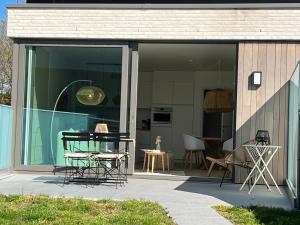 eine Glaserweiterung eines Hauses mit einem Tisch und Stühlen in der Unterkunft Appartement 4 Pers Garage Parkzicht Nieuwpoort Stad in Nieuwpoort
