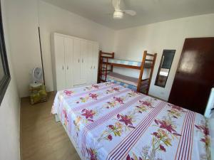 een slaapkamer met een bed en een stapelbed bij Apartamento cidade ocian Praia Grande in Praia Grande