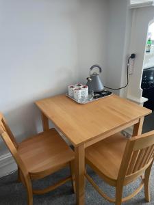 a wooden table with two chairs and a lamp on it at The Lugger Fowey in Fowey