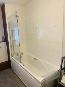 a bathroom with a tub and a glass shower at The Lugger Fowey in Fowey