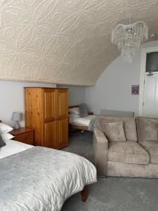 a bedroom with a couch and a bed and a bed and a room with at The Lugger Fowey in Fowey