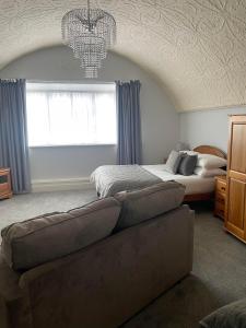 1 dormitorio con sofá, cama y lámpara de araña en The Lugger Fowey, en Fowey