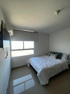- une chambre avec un grand lit et une fenêtre dans l'établissement apartamento barranquilla villa campestre!, à Puerto Colombia