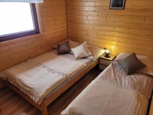 1 dormitorio con 2 camas en una cabaña de madera en Siedlisko Wataha en Wołkowyja