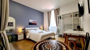 Fortuna Guest House في سيراكوزا: غرفة نوم بسرير وطاولة ومكتب