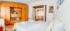 a bedroom with a white bed and wooden cabinets at Heart City Apartment in Ohrid