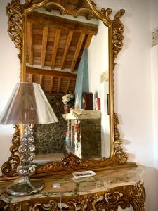 um espelho em cima de uma mesa com um candeeiro em Casa Malù Suvereto Antica Dimora with two bedrooms em Suvereto