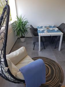 a swing chair in a living room with a table at Apartmani EvaMaria in Poreč