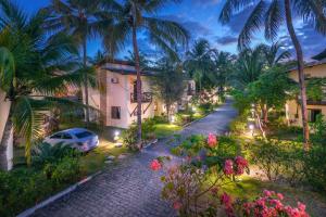 uma rua num resort com palmeiras e flores em Serhs Villas Da Pipa Hotel em Pipa