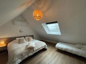 a attic bedroom with a bed and a window at Les oiseaux du paradis in Saint-Aignan
