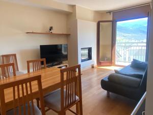 a living room with a dining room table and a television at Cálido piso -BONAVISTA- ¡IDEAL PARA TI Y LOS TUYOS ! in Sort