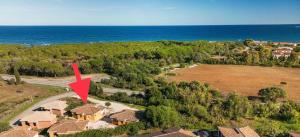 eine Luftansicht eines Hauses mit einem roten Pfeil in der Unterkunft Villetta Capo Comino 500 m DAL MARE in Siniscola