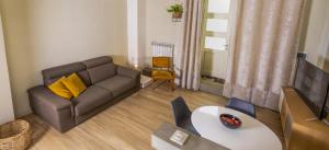 een woonkamer met een bank en een tafel bij Appartamento moderno Second House Catania 26 in Catania