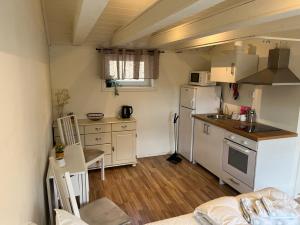 a small kitchen with a refrigerator and a sink at Guest House Stare in Strömstad