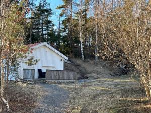 a white shed in the middle of a forest at Guest House Stare in Strömstad