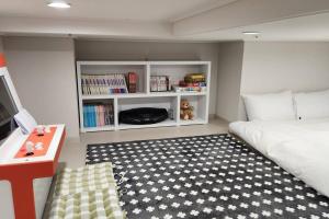 1 dormitorio con cama y estante para libros en The Castle Ocean Marina Double Suite, en Yeosu