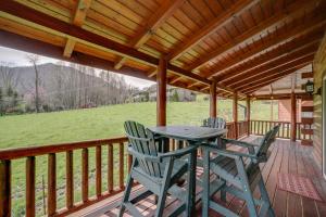a patio with a table and chairs on a deck at Maggie Valley Cabin with Private Hot Tub and Game Room in Maggie Valley