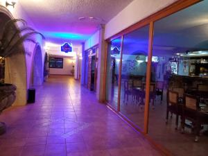 um corredor vazio com luzes roxas num restaurante em HOTEL MISION SANTA MARIA em San Quintín