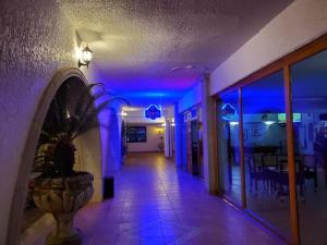 San Quintín的住宿－HOTEL MISION SANTA MARIA，蓝色灯的建筑走廊