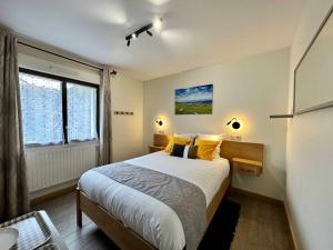 a bedroom with a bed with yellow pillows and a window at Les Chambres Du Vignoble in Ammerschwihr