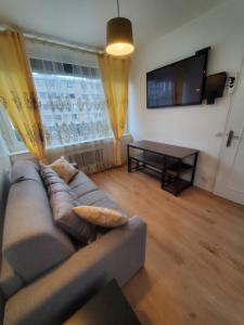 a living room with a couch and a table at Apartment 2 or 3 bedrooms near Paris in Suresnes