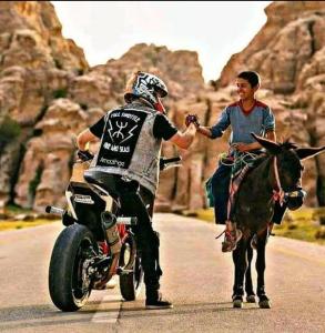un hombre está de pie junto a un hombre en una motocicleta en Maison AFA, en Tafraoute