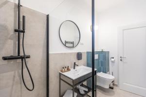 bagno con doccia, lavandino e specchio di Richter Residence a Braşov
