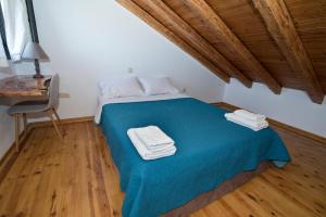 Un dormitorio con una cama azul con toallas. en Mare e Pietra, en Monemvasia