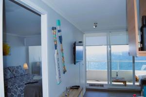 1 dormitorio con cama y ventana grande en Vista al Mar & Descanso de lujo, Wifi & Parking Privado & 2"SmartTV, en Concón