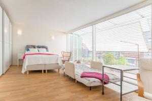 a bedroom with two beds and a large window at Modernes, sonniges Appartement im Herzen von Düsseldorf in Düsseldorf