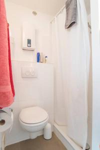 een witte badkamer met een toilet en een douche bij Modernes, sonniges Appartement im Herzen von Düsseldorf in Düsseldorf