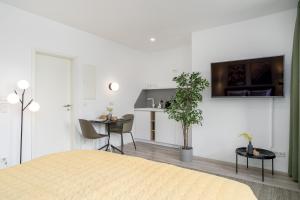 ein Zimmer mit einem Bett und einem Tisch und einer Küche in der Unterkunft BRIGHT Dortmund City Center in Dortmund