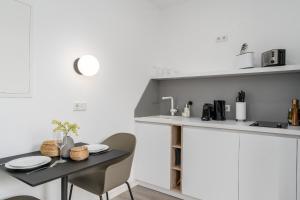 eine kleine Küche mit einem Tisch und Stühlen in der Unterkunft BRIGHT Dortmund City Center in Dortmund