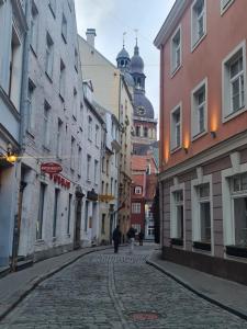 a cobblestone street in a city with buildings at Old Town Apartment in Riga