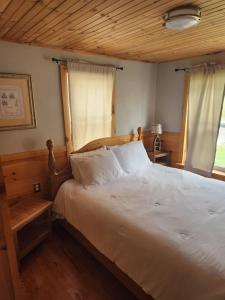 um quarto com uma cama branca e um tecto de madeira em Little Green Cottage - The perfect retreat em Butler