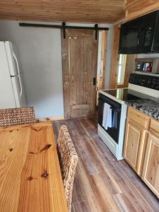 uma cozinha com piso em madeira e um fogão forno superior em Little Green Cottage - The perfect retreat em Butler