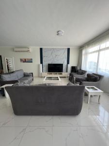 a living room with a couch and a tv at درة العروس فخامة فان بيتش in Durat  Alarous