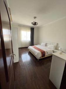 a white bedroom with a bed and a window at درة العروس فخامة فان بيتش in Durat  Alarous