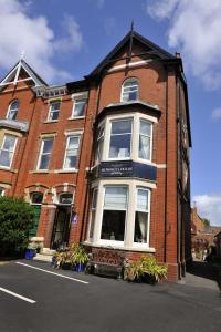 un edificio de ladrillo rojo con una ventana blanca en Howarth House, en Lytham St Annes