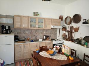 a kitchen with a wooden table and a stove top oven at Nektarios Village House in Neápolis